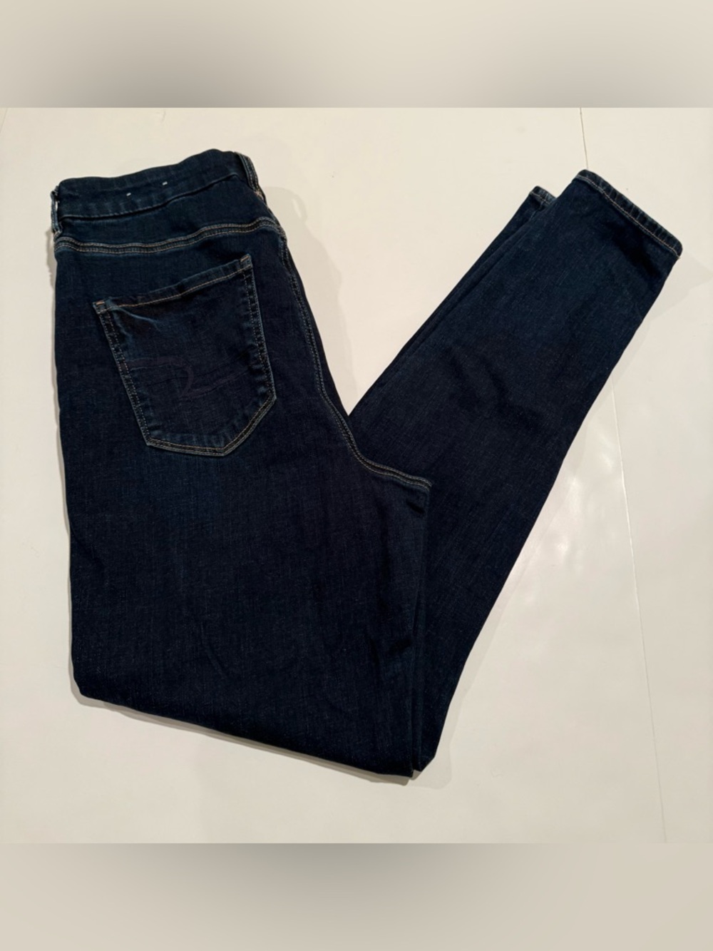 American Eagle dark blue denim jeans with tan leather patch